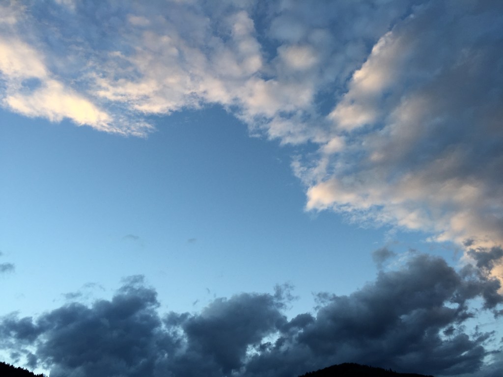 A picturesque sky filled with a mix of white and grey clouds against a blue backdrop, showcasing different cloud formations and a serene atmosphere.